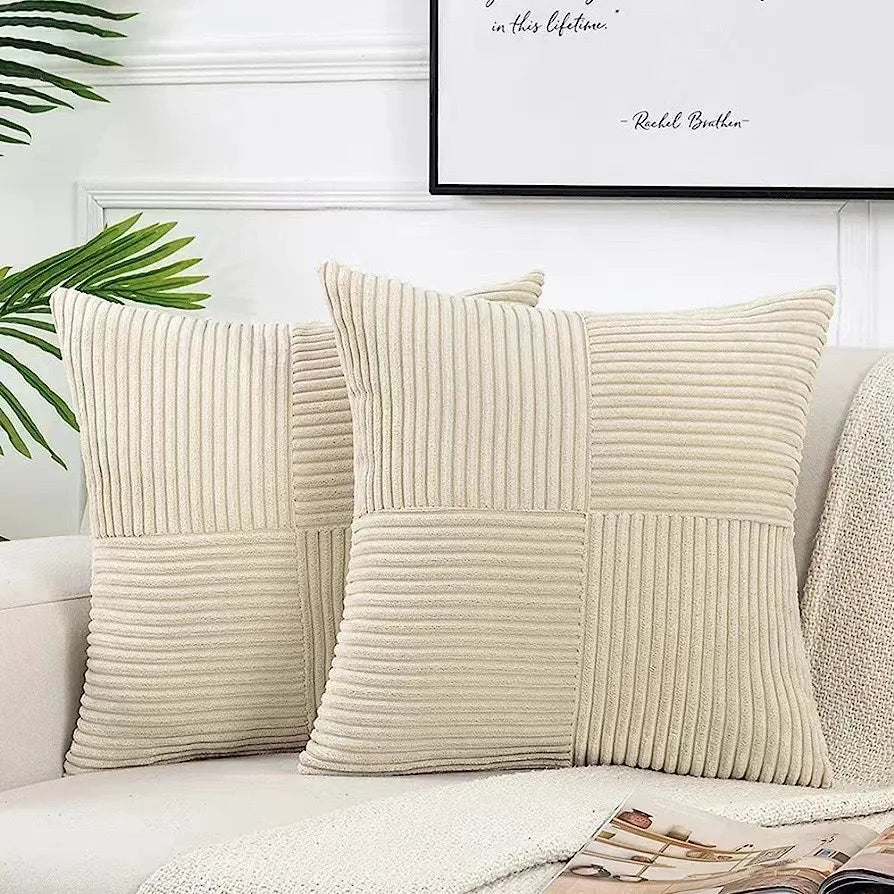 Beige textured throw pillows on a sofa with a plant and framed quote in the background.